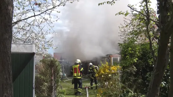 Feuerwehrleute bei einer brennenden Gartenlaube in Lingen.