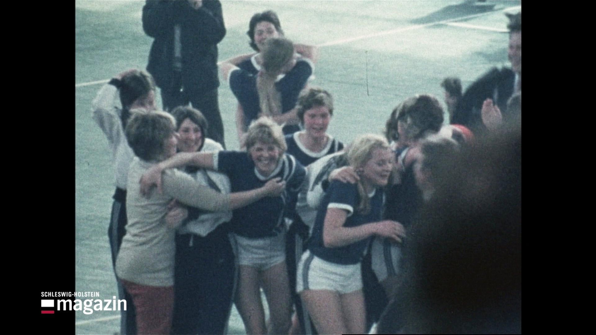 Sportlerinnen feiern auf einem Spielfeld. | Screenshot