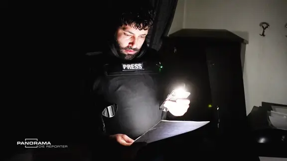 Der NDR Reporter Sulaiman Tadmory liest in einer Akte.