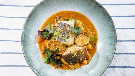 Kartoffel-Fisch-Curry mit Mangold auf einem hellen Teller