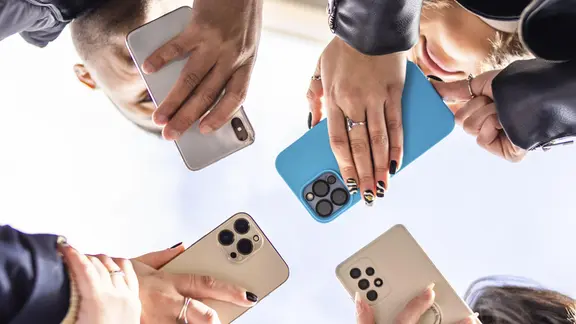 Niedriger Winkel einer Gruppe von Personen, die das Handy halten.