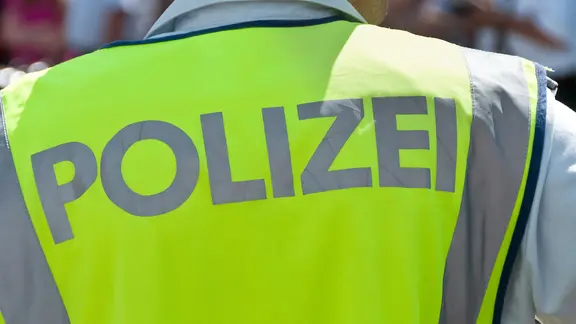 Ein Polizist von hinten mit einer Leuchtweste