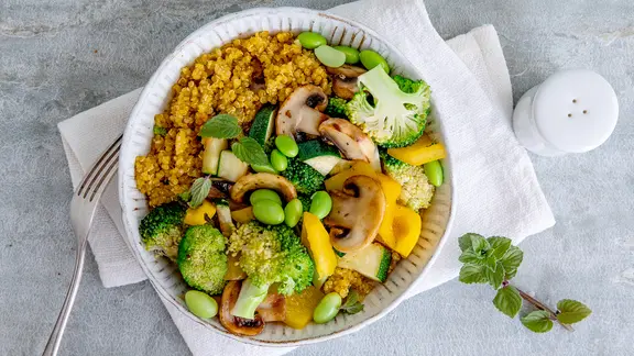 Eine Schale mit Quinoa und gedünstetem Gemüse.