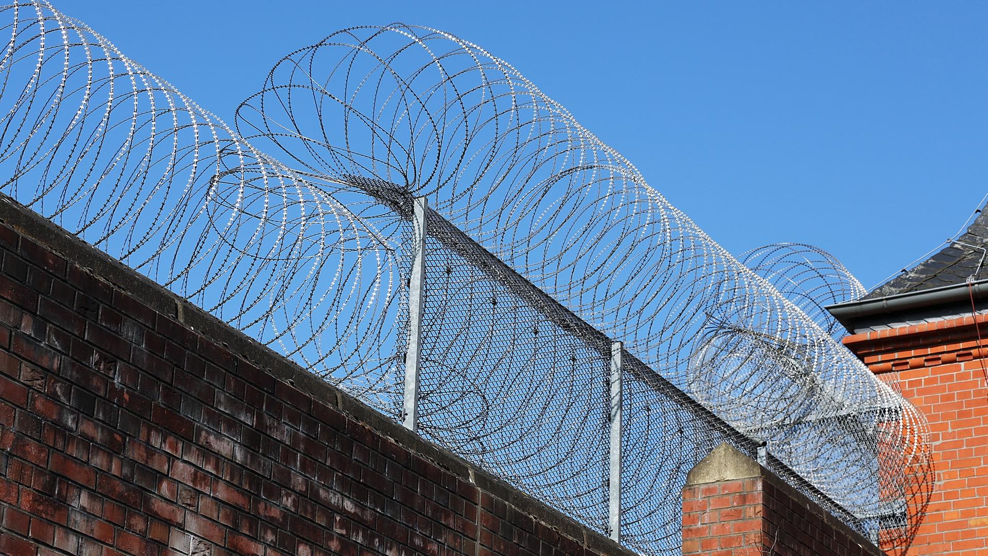 Stacheldraht sichert den Zaun der JVA Neumünster bei Sonnenlicht. | NDR, Pavel Stoyan