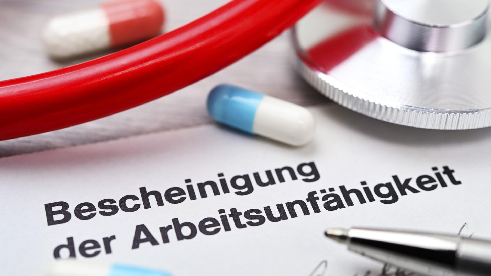 Bescheinigung der Arbeitsunfähigkeit mit Tabletten und Stethoskop (Themenbild). | imageBROKER, Christian Ohde