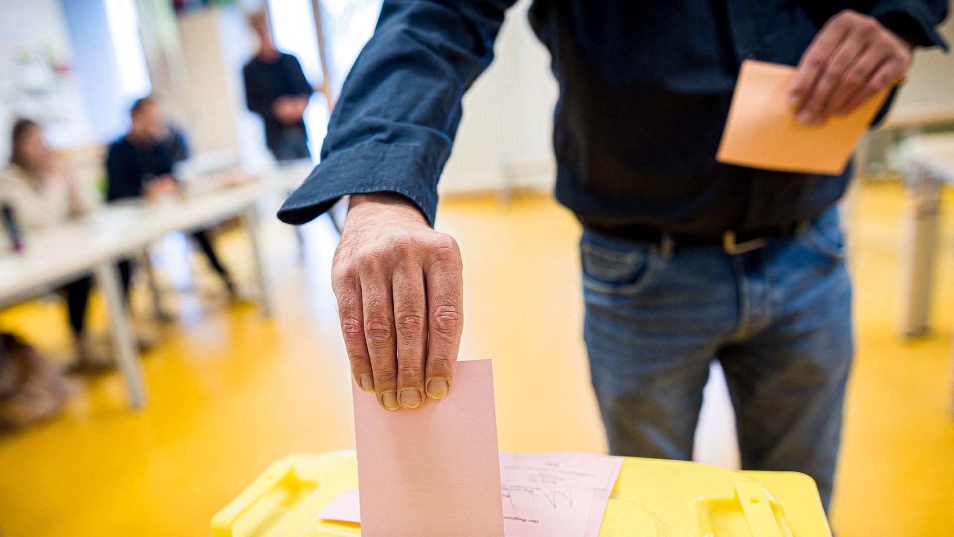 Ein Wähler wirft in einem Wahllokal seinen Stimmzettel in eine Wahlurne. | dpa-Bildfunk, Moritz Frankenberg