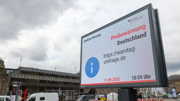 An den Landungsbrücken ist eine Meldung zum Probealarm auf einer Anzeigetafel zu sehen.