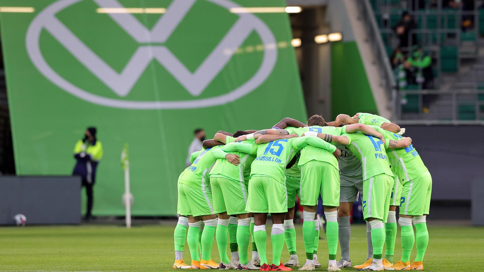 Jugadores del VfL Wolfsburg frente al logo de VW