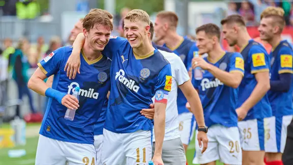 Magnus Knudsen (l.) und Alexander Bernhardsson von Holstein Kiel liegen sich in den Armen