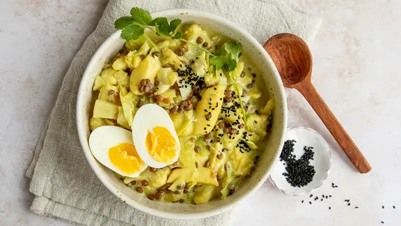 Ein Kohlcurry mit Pak Choi, darauf ein aufgeschnittenes gekochtes Ei.
