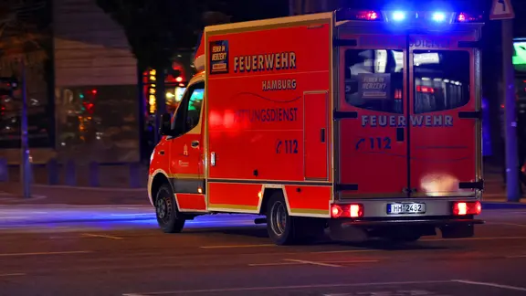 Ein Krankenwagen der Hamburger Feuerwehr fährt mit Blaulicht zu einem Einsatz.