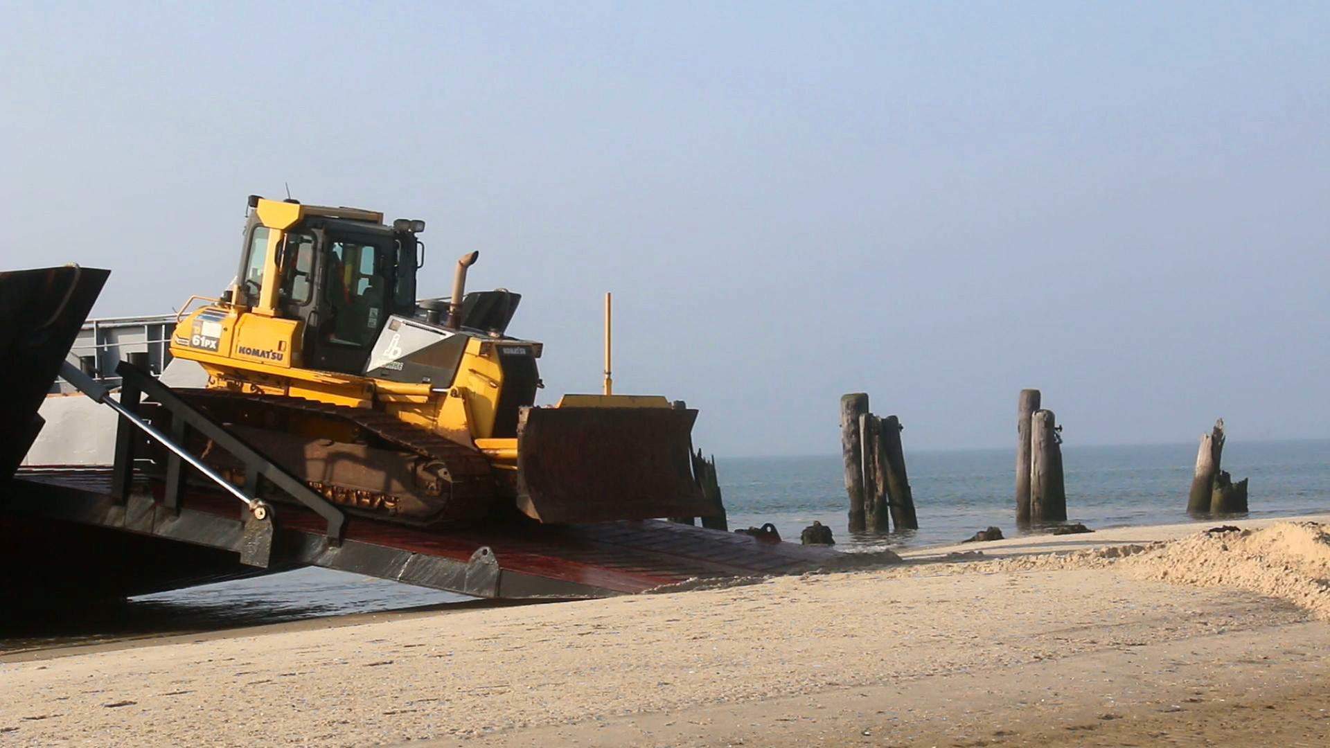Ein Radlader fährt von einem Schiff an einen Strand auf der ostfriesischen Insel Wangerooge. | NonstopNews