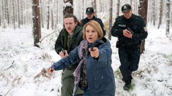 Katrin König (Anneke Kim Sarnau) rennt mit gezogener Waffe und Verstärkung durch einen Wald