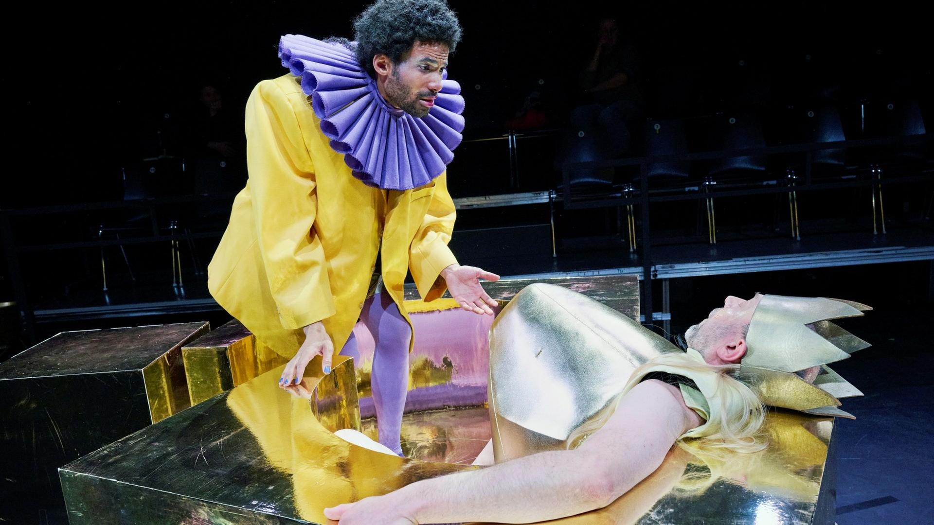 Zwei Schauspieler auf einer Bühne, einer von ihnen liegend mit goldener Krone | Thalia Theater Hamburg, Katrin Ribbe