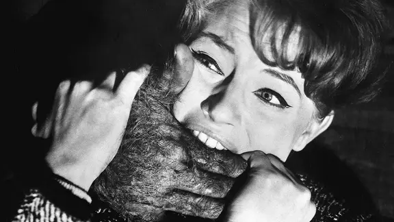 In einer Szene aus "Die toten Augen von London" beißt eine Frau verzweifelt in eine große, haarige Hand, die ihr den Mund zuzuhalten versucht.