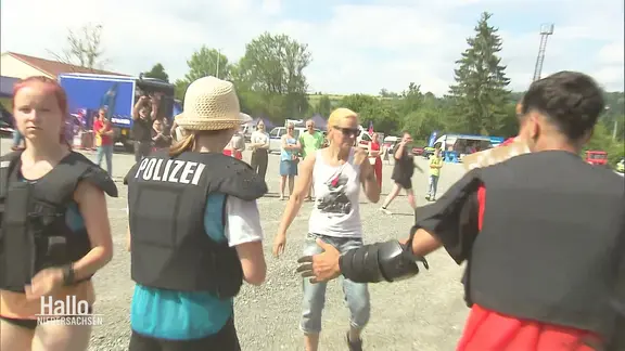 Jugendliche proben einen Polizeieinsatz auf einer gespielten Demonstration.