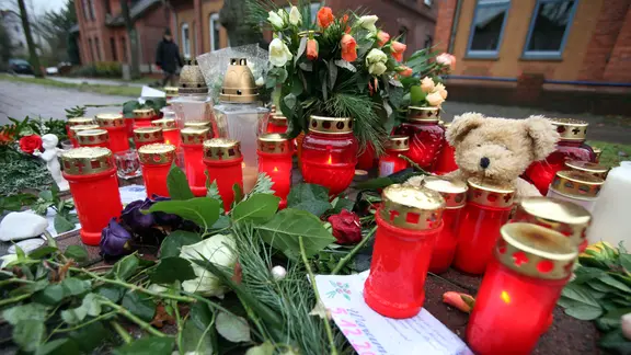 Blumen und Kerzen schmücken in Stolzenau einen Bürgersteig.