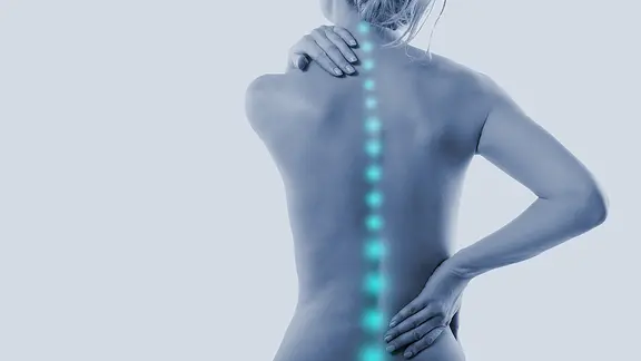 Eine Frau greift sich an Nacken und am Rücken, ihre Wirbelsäule wird als blaue Linie angedeutet, um auf einen Schmerz hinzuweisen.