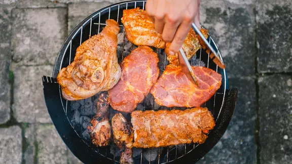 Auf einem Grill wird Fleisch gegrillt.