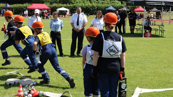 Kinder bei einem Feuerwehrwettkampf.