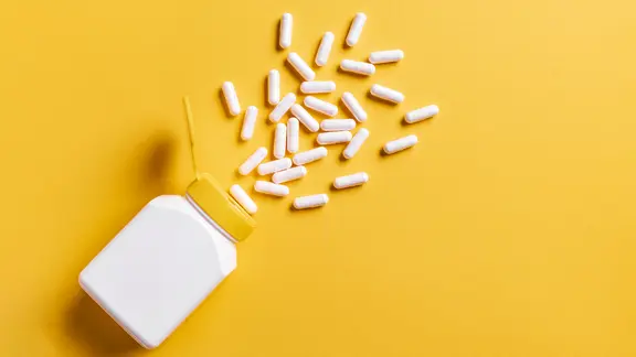 Zink: Tabletten mit Zink ergießen sich aus einer Flasche