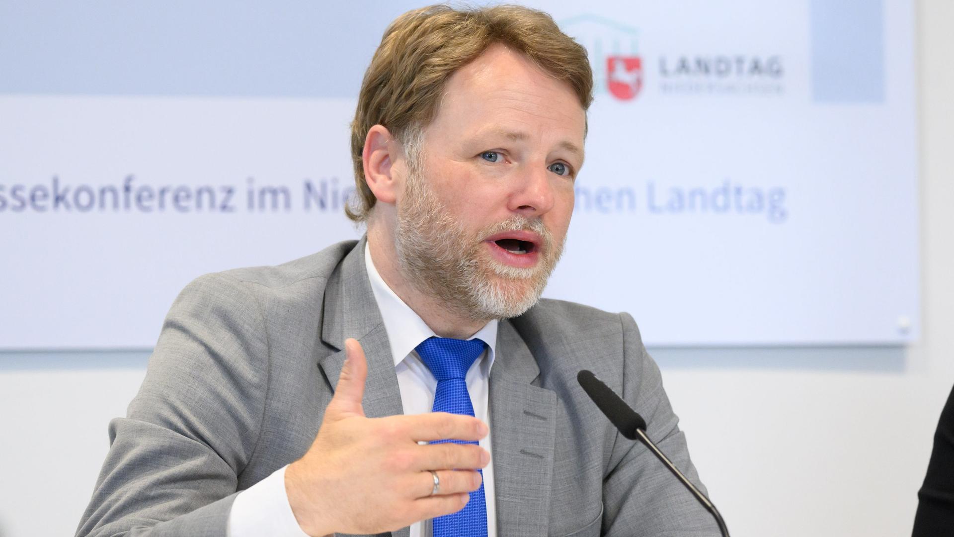 Gerald Heere (Grüne) spricht bei einer Pressekonferenz. | picture alliance/dpa, Julian Stratenschulte
