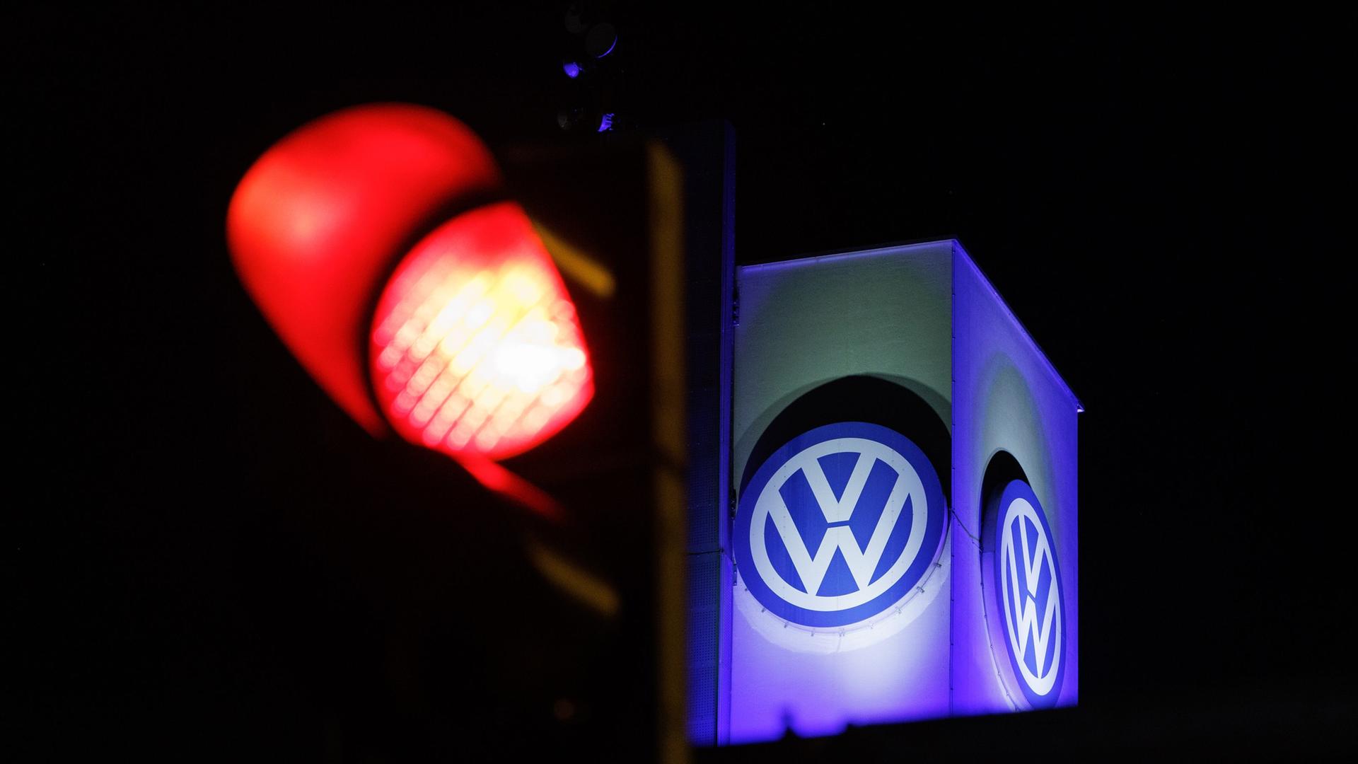 Das Volkswagen-Emblem hinter einer roten Ampel in Osnabrück. | dpa, Friso Gentsch