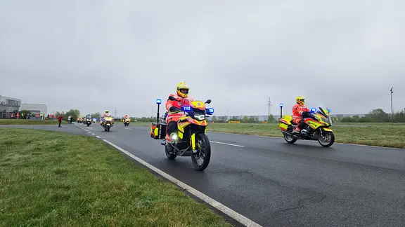 Mitglieder der Johanniter-Motorradstaffel fahren gemeinsam eine Straße entlang.