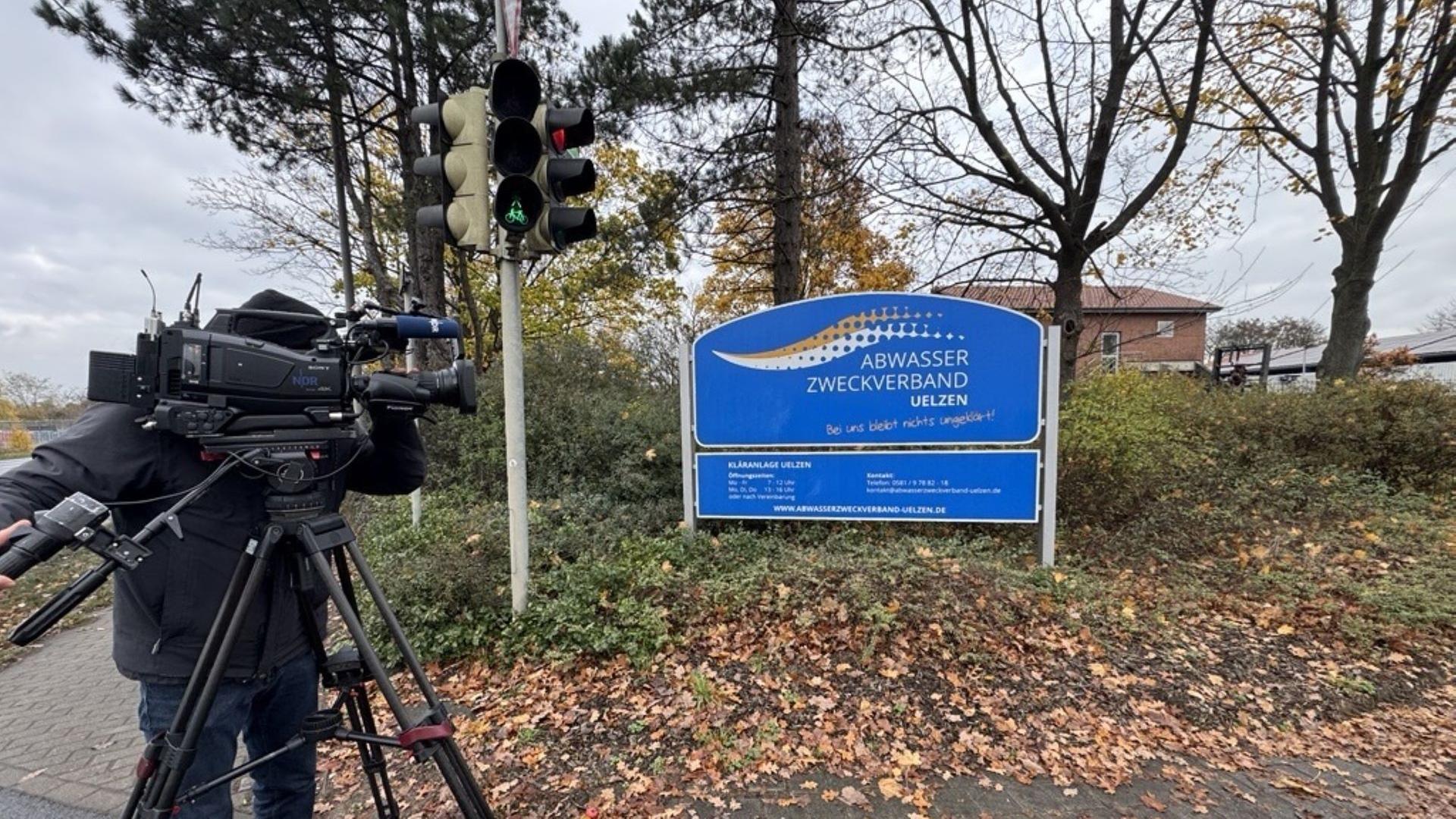 Ein Mann filmt mit Fernsehkamera das Firmenschild des Abwasserverbandes Uelzen | NDR/Lisa Göllert