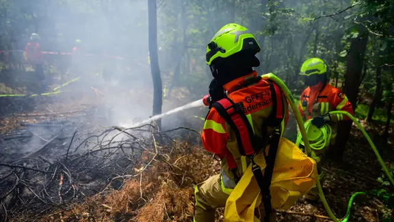Einsatzkräfte der Feuerwehr üben die Bekämpfung von Waldbränden.