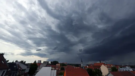 Dunkle Wolken über den Dächern einer Stadt.