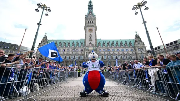 HSV-Maskottchen Dino Hermann steht vor dem Hamburger Rathaus bei der Aufstiegsfeier der HSV-Teams der Frauen und Männer.