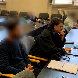 Ein Mann (l.) sitzt in einem Gerichtssaal in Hamburg. Er soll sein Kind entführt und den Flugbetrieb am Hamburger Flughafen stundenlang lahmgelegt haben.