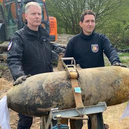 Oliver Kinast und Mirko Haack vom Kampfmittelräumdienst stehen hinter einer Bombe.