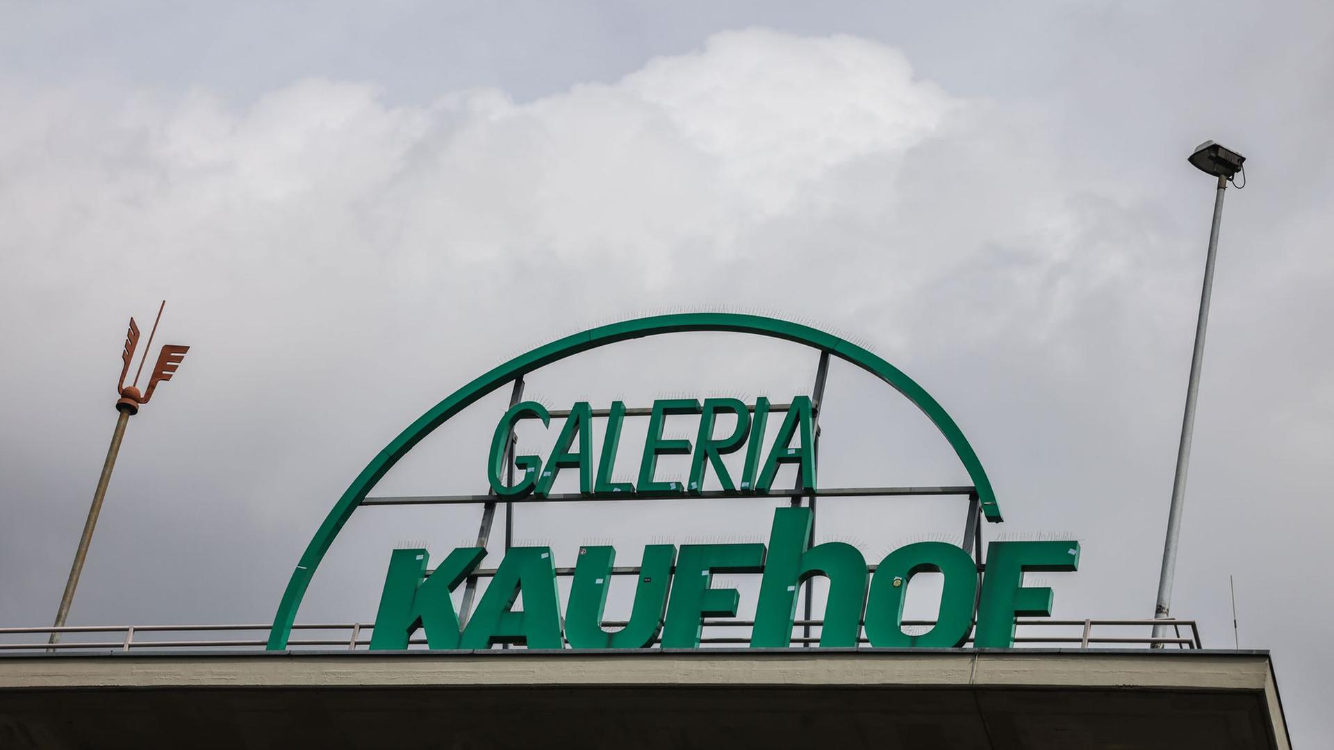 Ein Kaufhof Schriftzug steht auf dem Dach einer Filiale der Warenhauskette Galeria Karstadt Kaufhof.  | Oliver Berg/dpa