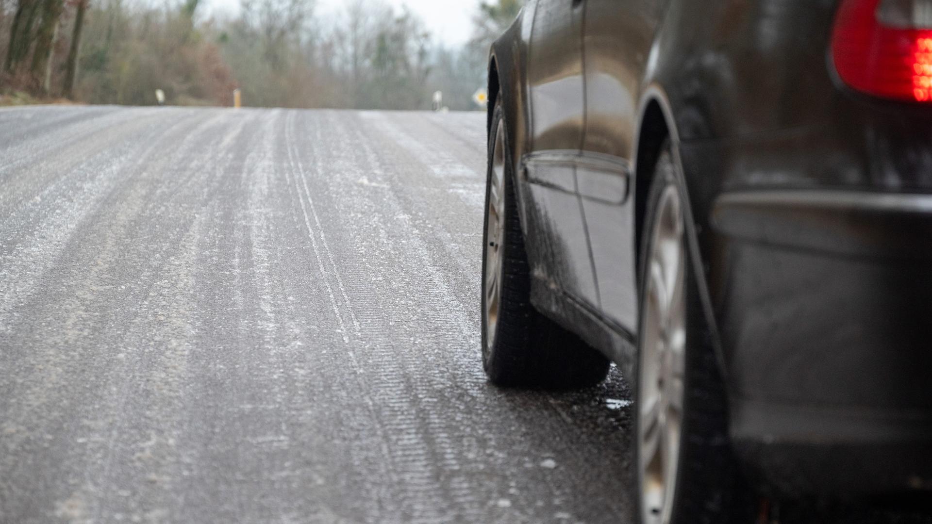 Ein Auto steht auf einer glatten Straße. | picture alliance/dpa, Harald Tittel
