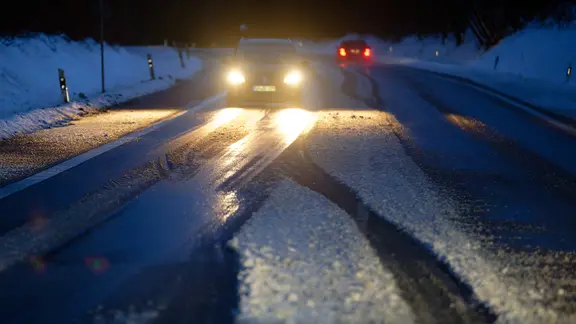 Autos fahren auf einer glatten Straße. | dpa, Henning Kaiser Autos fahren auf einer glatten Straße.