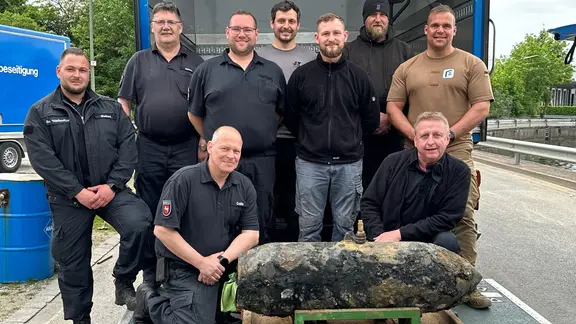 Ein Team aus Spezialisten steht hinter der entschärften Bombe.