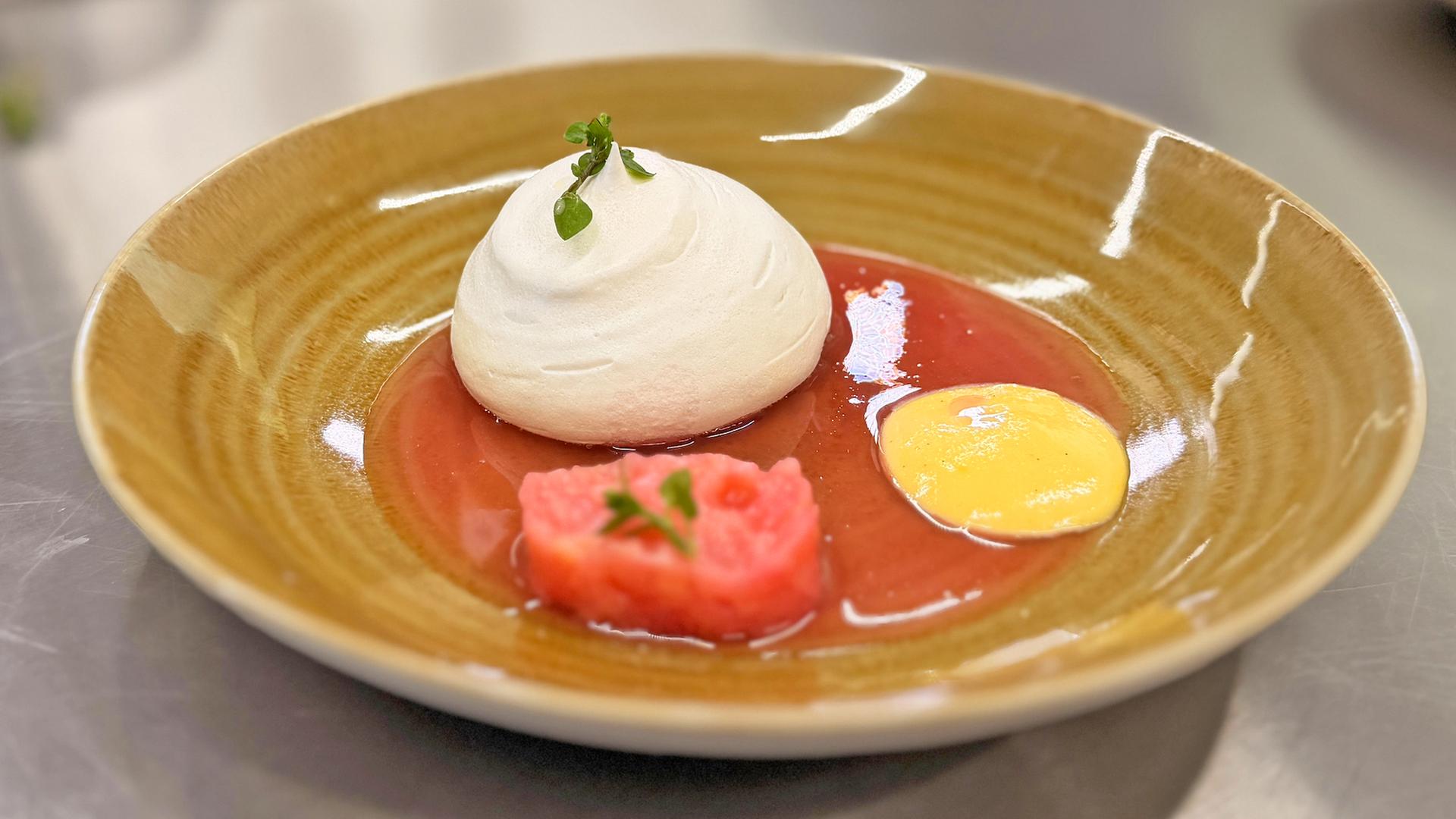 Eine Pavlova mit Rhabarberkompott und Eierlikörcreme auf einem Teller.  | NDR, Lisa Knittel