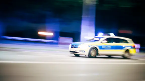 Ein Streifenwagen fährt nachts durch Hannover.