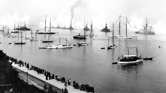Kieler Woche um 1905: Schiffe auf der Förde geben Salutschüsse ab.