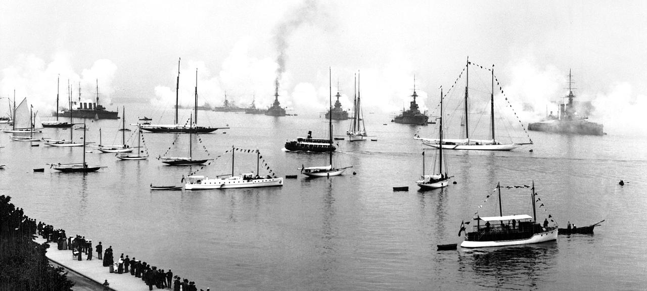 Kieler Woche um 1905: Schiffe auf der Förde geben Salutschüsse ab.