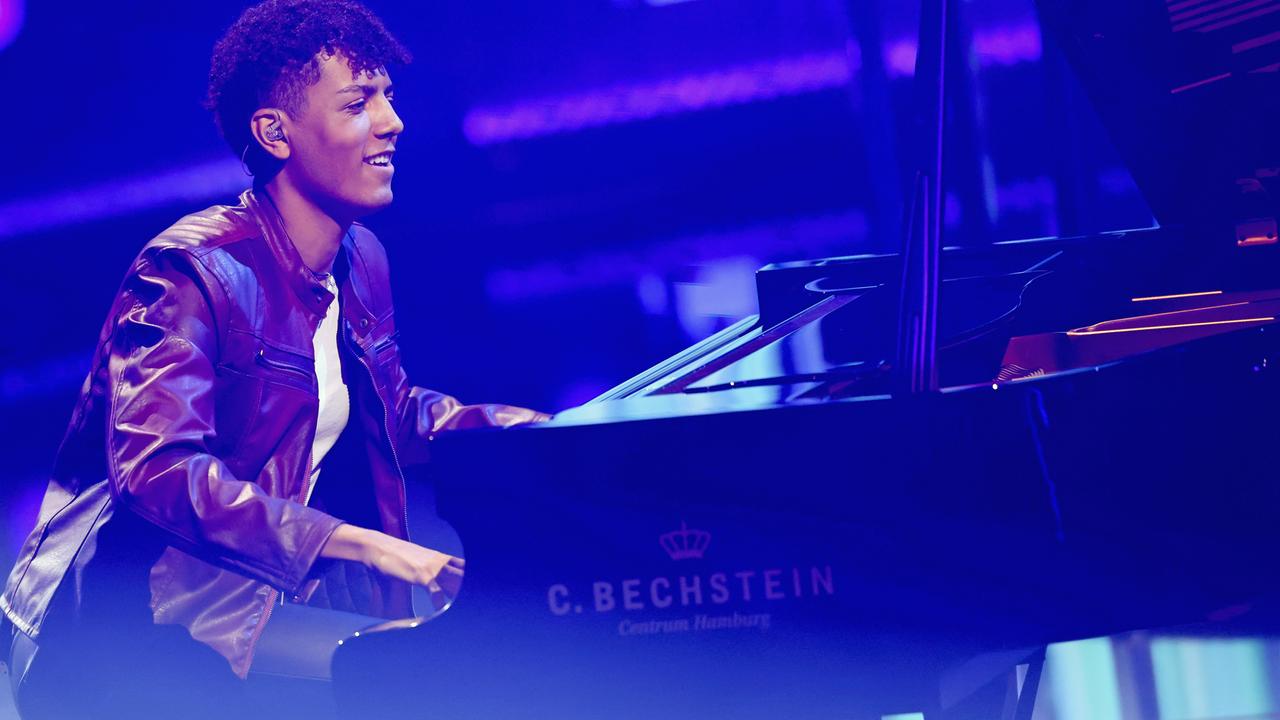 Der Pianist Louis Philippson spielt auf einer in blaues Licht getauchten Bühne.