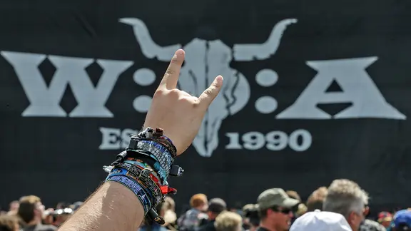 Ein Festivalbesucher des W.O.A. (Wacken Open Air) zeigt am 01.08.2015 in Wacken (Schleswig-Holstein) den Metal-Gruß, die Pommesgabel, vor Beginn eines Konzerts.