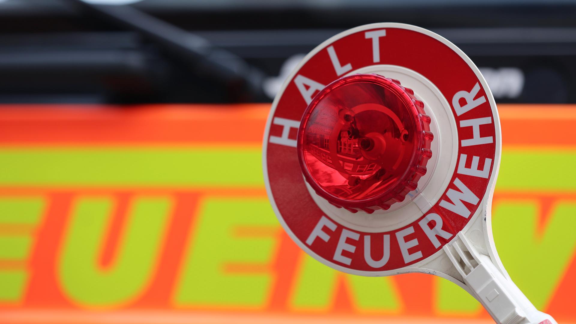 Eine Feuerwehrkelle ist vor einem Feuerwehrauto zu sehen. | NDR, Pavel Stoyan
