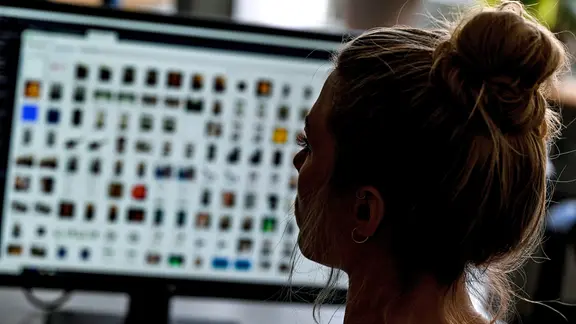 Eine Kriminaloberkommissarin sitzt in einem Büro vor einem Auswertungscomputer auf der Suche nach Kinderpornografie.