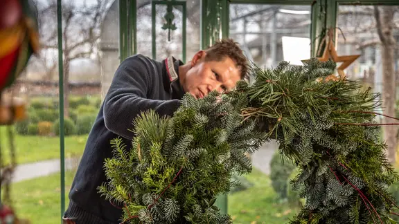 Peter Rasch arbeitet an einem Adventskranz