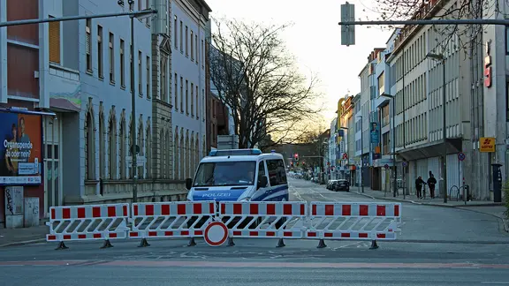 Polizeiwagen hinter einer Straßensperre. | NDR, Paul Hintzke Polizeiwagen hinter einer Straßensperre.