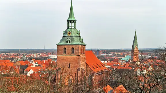 Der mächtige Bau der Michaeliskirche stammt aus dem 14. und 15. Jahrhundert. | imago images/Frank Sorge Die St.-Michelis-Kirche in Lüneburg, im Hintergrund der Turm der Kirche St. Johannis