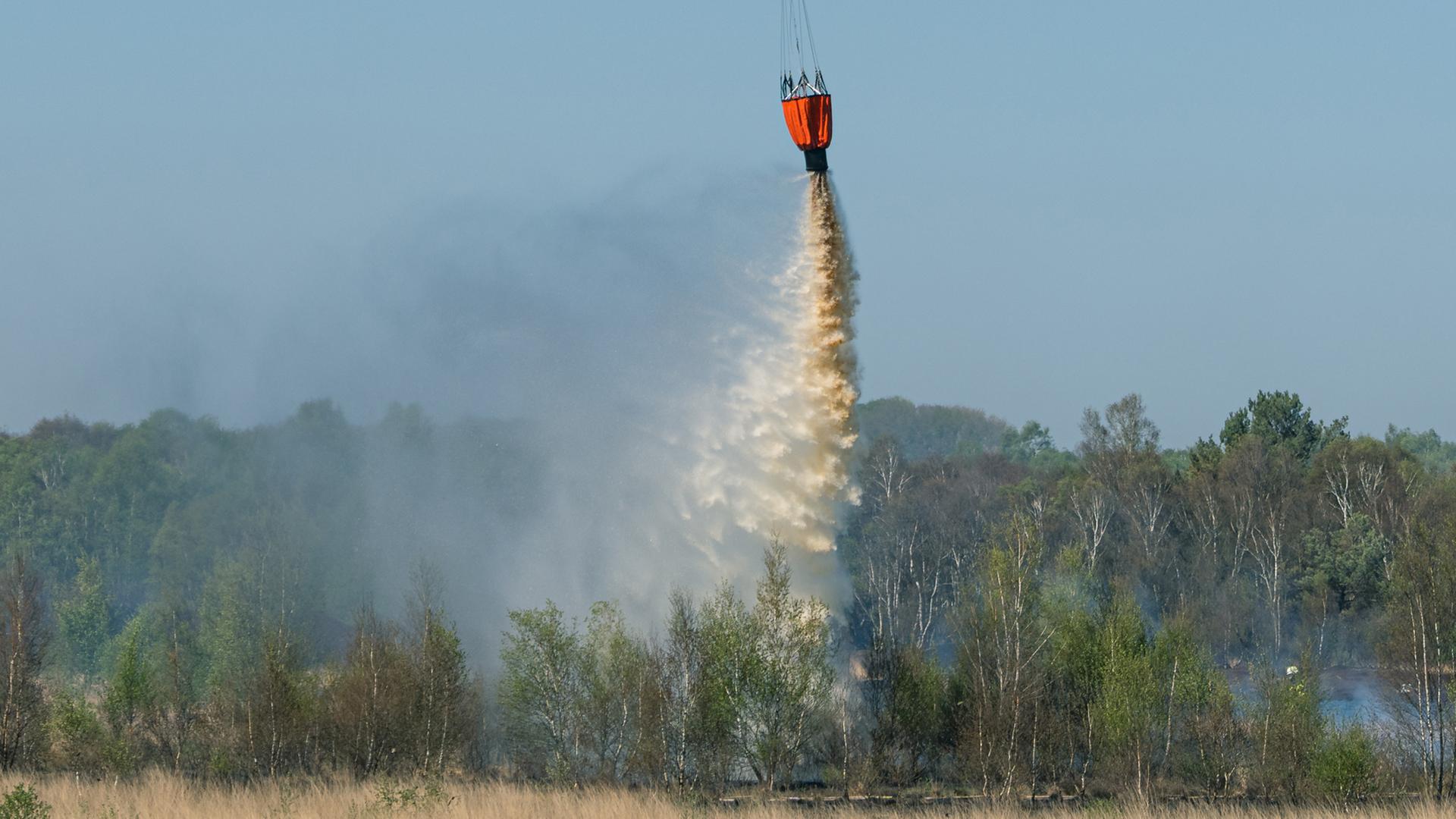 Ein Hubschrauber unterstützt die Löscharbeiten der Feuerwehr beim Moorbrand in der Nähe von Lohne. | dpa-Bildfunk, Mohssen Assanimoghaddam/dpa